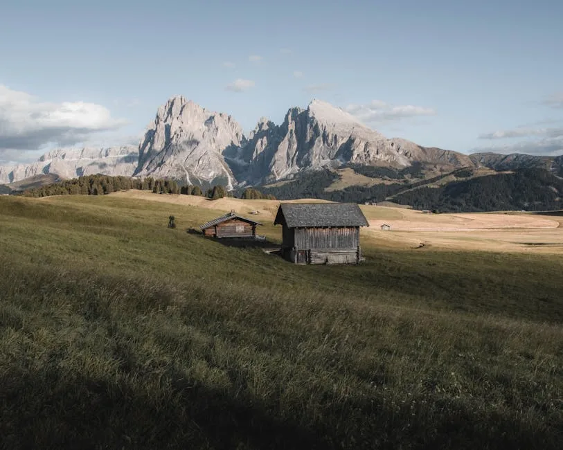 Chalets isolés dans une prairie face aux sommets des Dolomites
