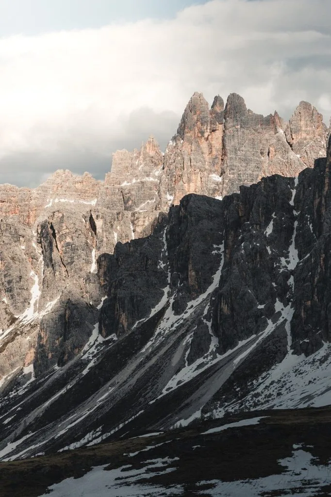 Falaises découpées des Dolomites avec plaques de neige et ombres