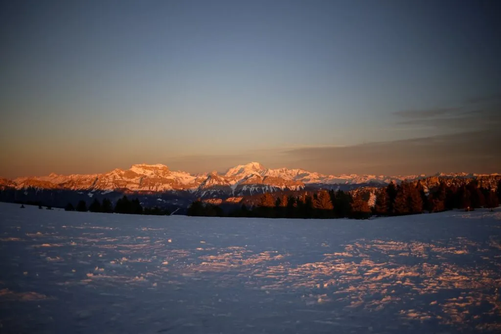 Coucher de soleil rosissant sur les sommets enneigés des Dolomites.