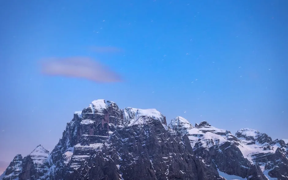 Pic enneigé des Dolomites sous ciel bleu crépusculaire étoilé