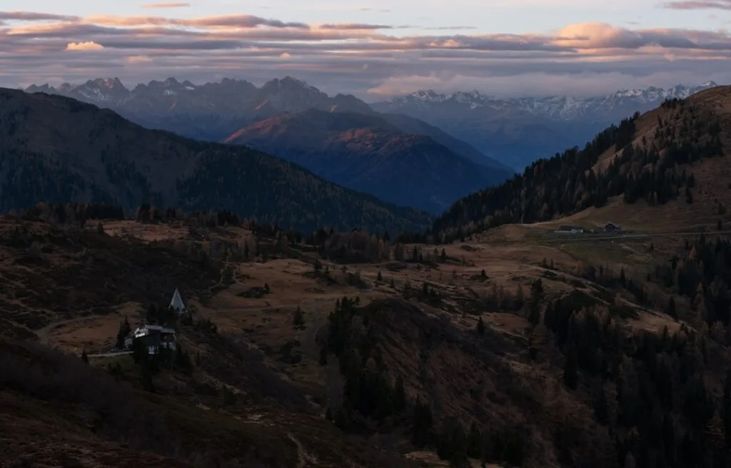 Vallée des Dolomites au crépuscule avec chalet isolé et chapelle
