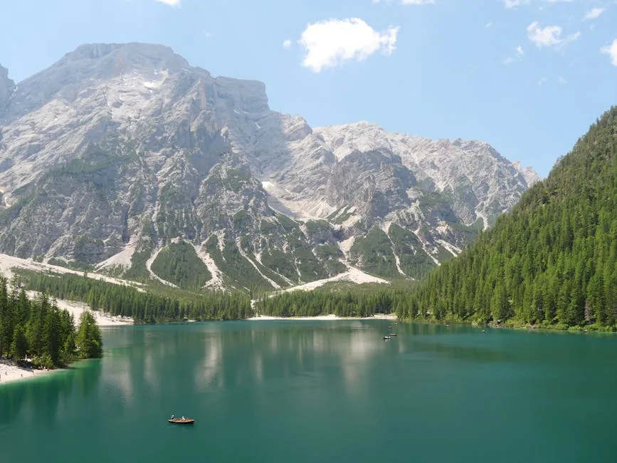 Barque solitaire sur le lac turquoise entouré de montagnes des Dolomites
