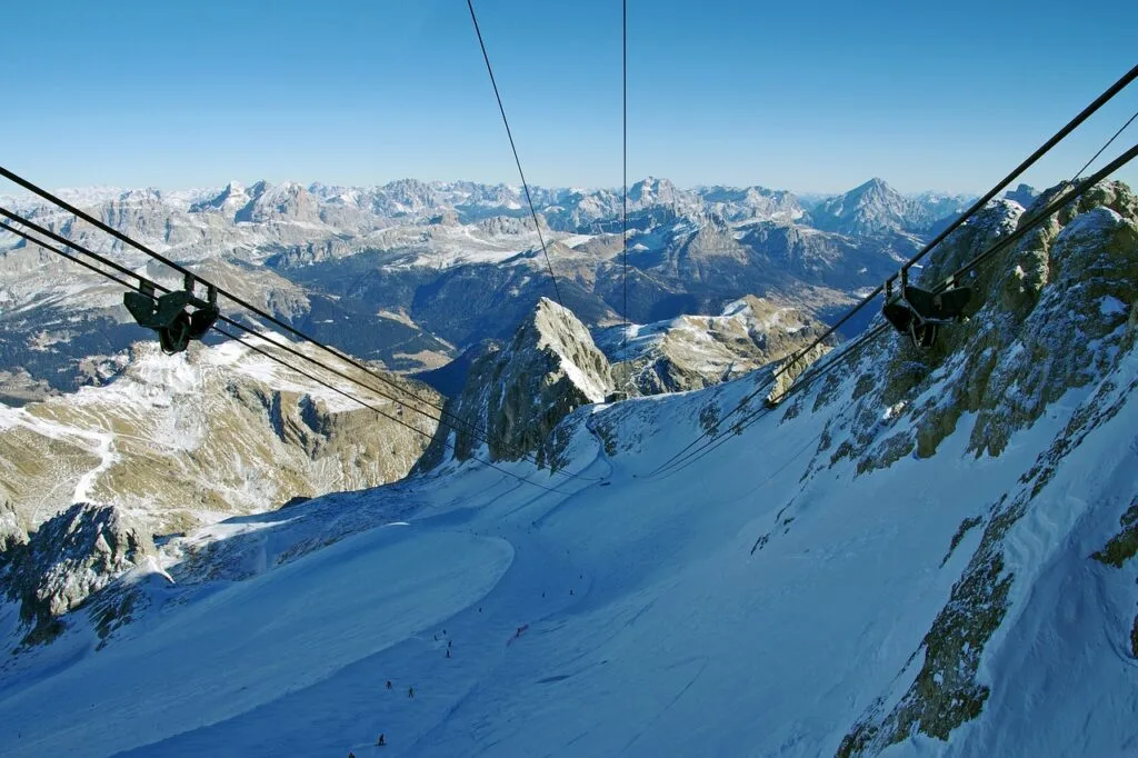 Câbles de téléphérique au-dessus d'une pente enneigée des Dolomites