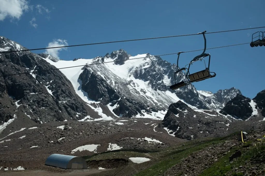 Télésiège vide encadrant glaciers et sommets des Dolomites