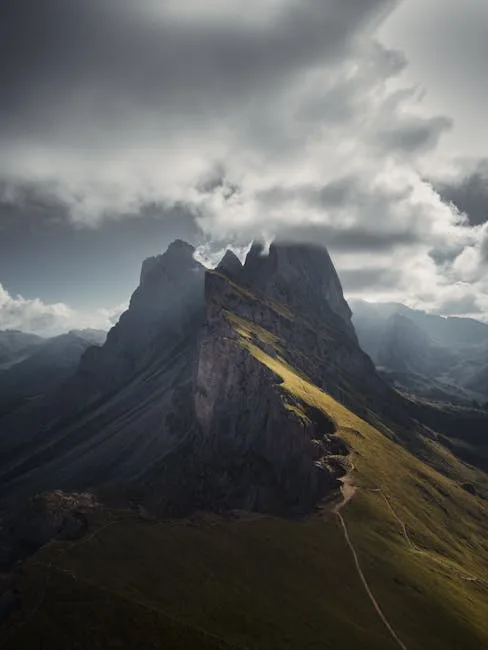 Arête escarpée baignée de lumière, sommets des Dolomites sous nuages menaçants