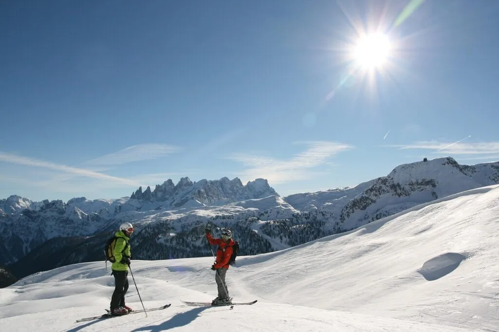 Deux skieurs discutent sur une pente enneigée des Dolomites