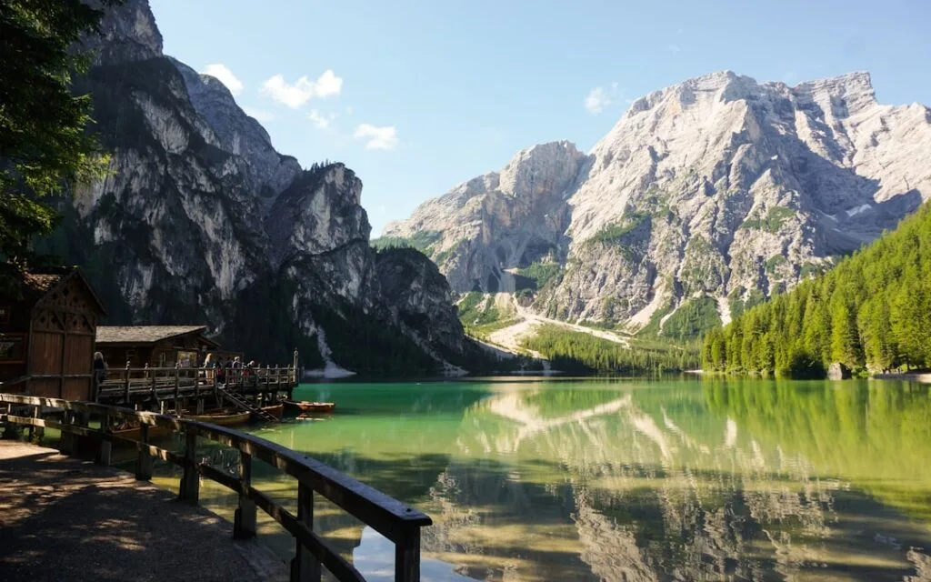 Barques et chalet sur ponton au bord du lac turquoise des Dolomites