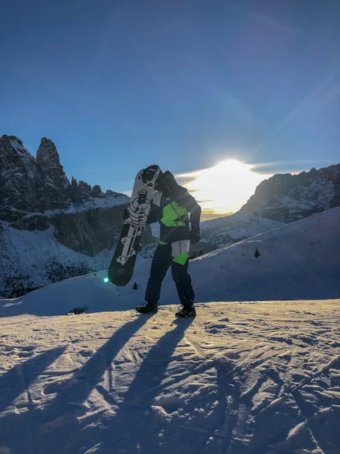 Snowboarder loopt over besneeuwde helling bij zonsondergang in de Dolomieten