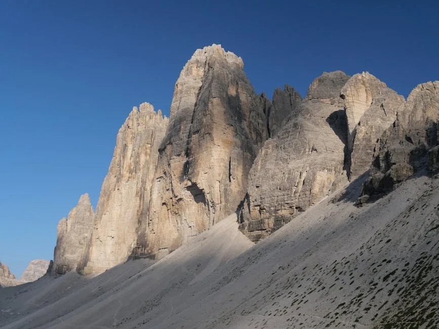 Tours rocheuses abruptes et pierriers au pied des parois des Dolomites