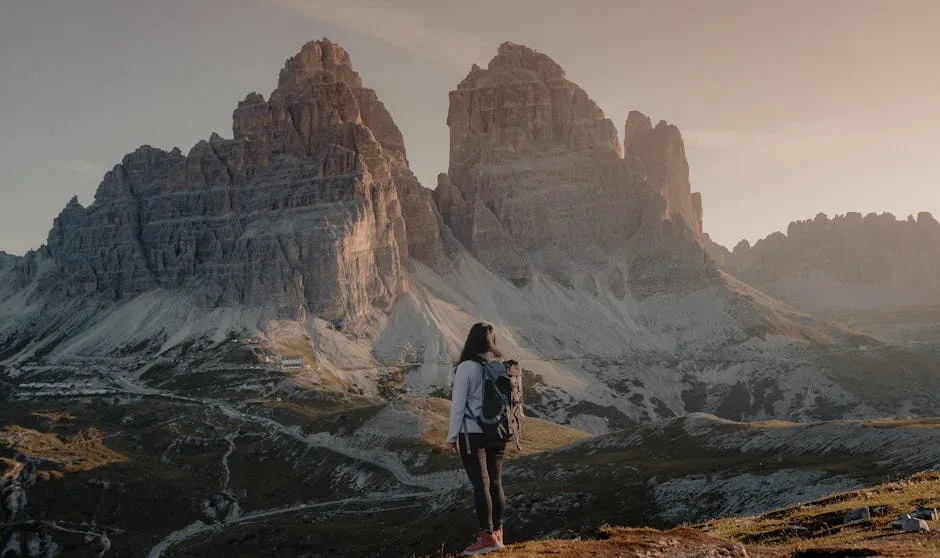 Randonneuse contemplant les imposantes Trois Cimes des Dolomites au coucher