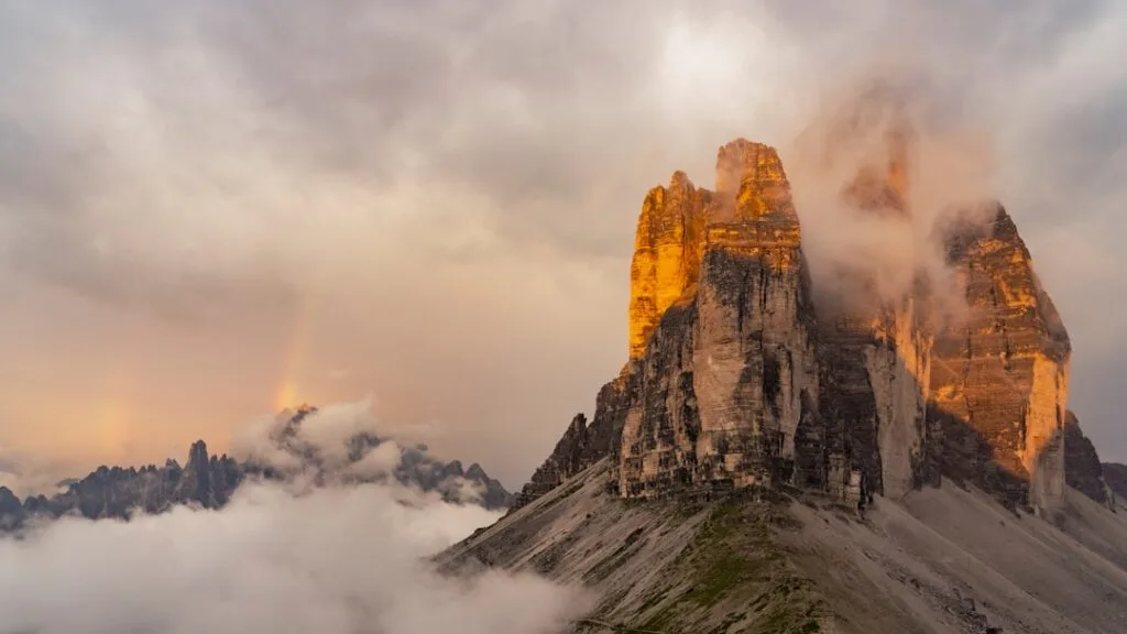 Les aiguilles des Dolomites baignées de lumière dorée et arc‑en‑ciel