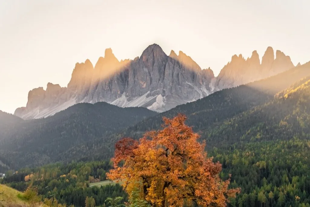Rayons du soleil illuminant une crête des Dolomites en automne