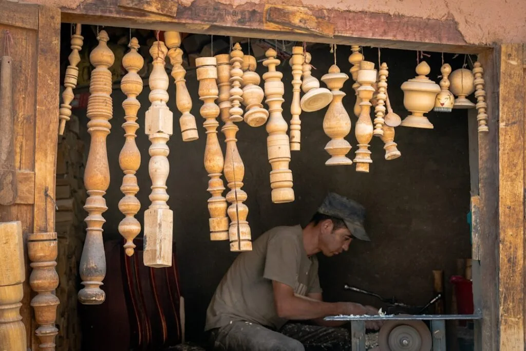 Un artisan tournant le bois sous des balustres suspendues dans les Dolomites