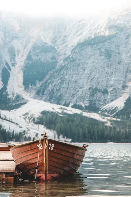 Barque numérotée amarrée au ponton devant les montagnes des Dolomites