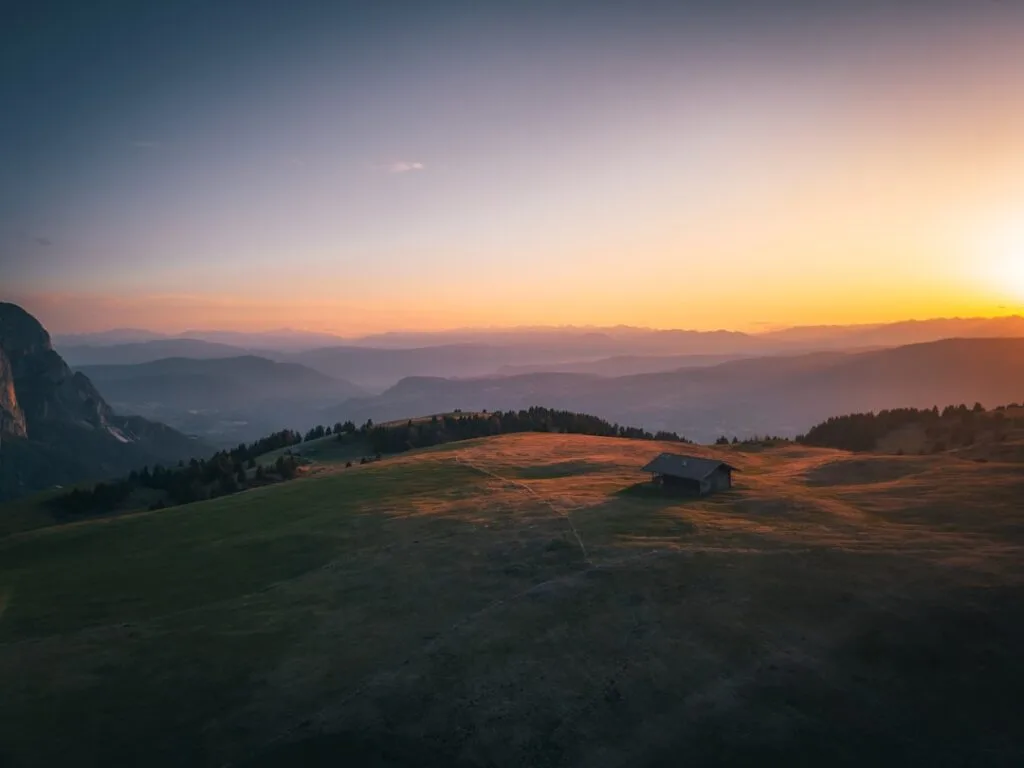 Chalet isolé sur alpage baigné par l'aube dans les Dolomites