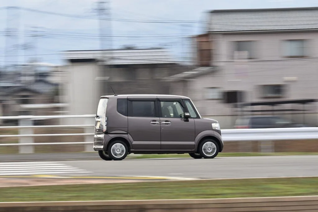 Petite voiture compacte grise roulant rapidement le long d'une rue