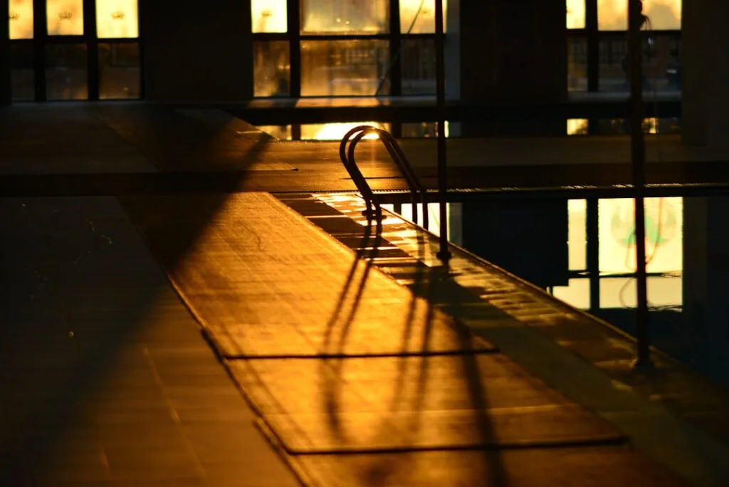 Échelle d'entrée et reflets dorés sur le bord d'une piscine thermale