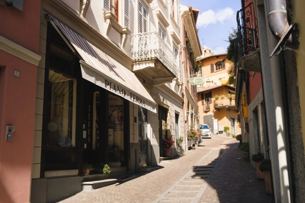 Ruelle pavée bordée de boutiques et d'enseignes dans un village des Dolomites.