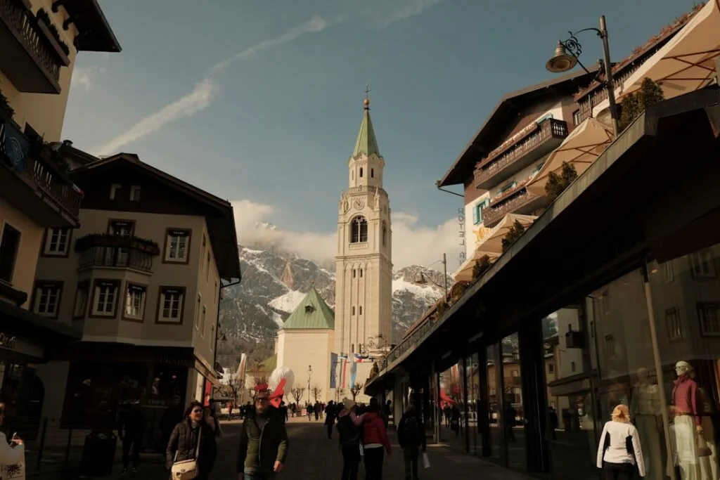 Rue commerçante d'un village alpin des Dolomites avec clocher central