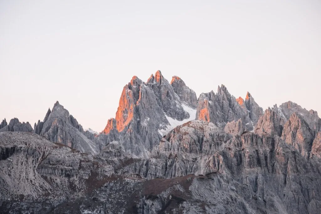 Éclat alpin rose sur aiguilles rocheuses des Dolomites au matin