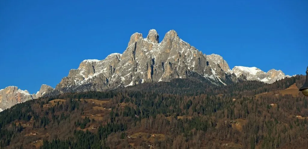 Massif rocheux surplombant la forêt, Dolomites, sommet encore enneigé