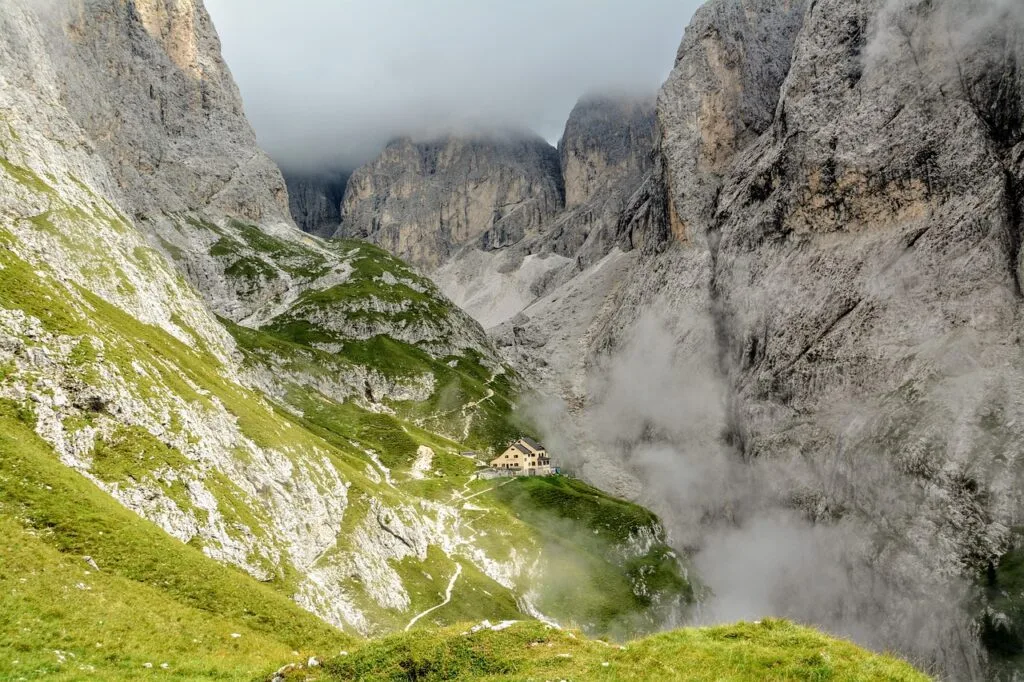 Refuge isolé niché dans une gorge brumeuse des Dolomites