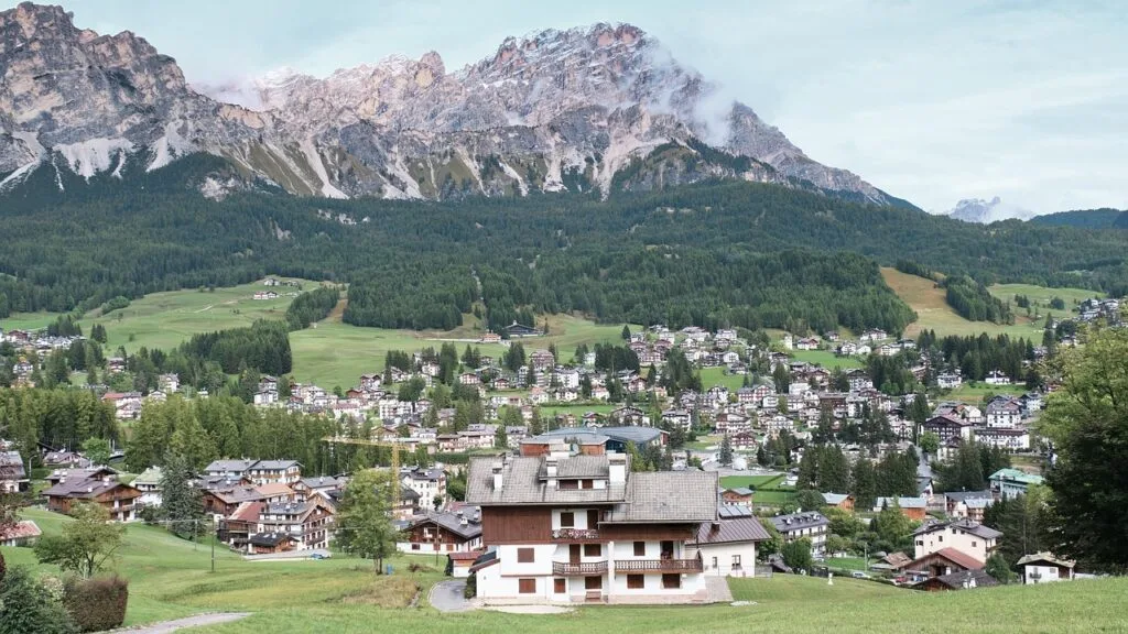 Village alpin dans les Dolomites au pied d'un massif rocheux