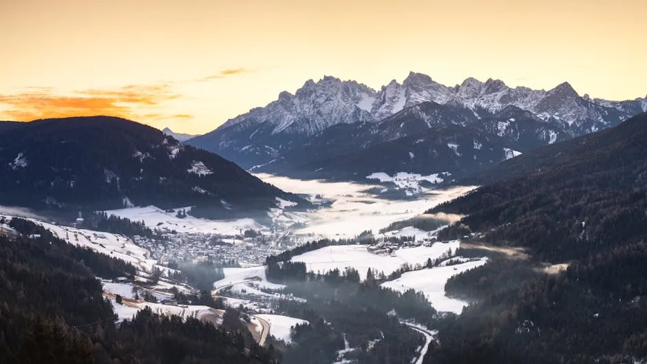 Village enneigé dans la vallée au pied des Dolomites au lever du soleil
