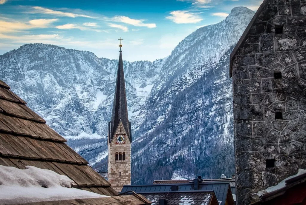 Clocher d'église avec horloge entre toits enneigés, Dolomites majestueuses