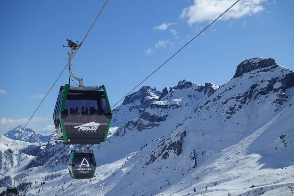 Télécabines Arabba remontant au-dessus des pentes enneigées des Dolomites